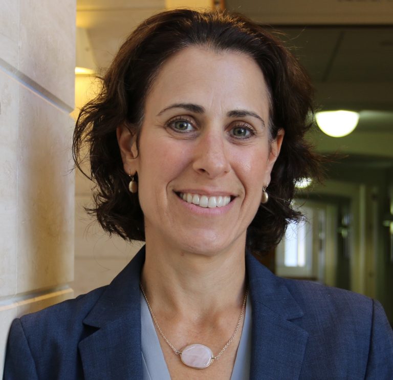 Erin Tanenbaum portrait shot wearing navy jacket smiling
